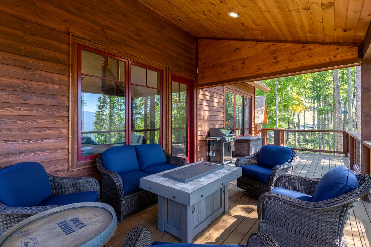 An outdoor dining area set with blue upholstered chairs and a wooden table, surrounded by trees for privacy and tranquility. The setup is perfect for morning coffee, outdoor meals, or quiet moments enjoying the fresh mountain air.