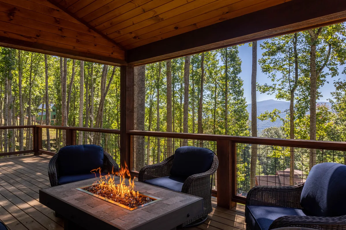 A cozy fire pit surrounded by comfortable outdoor seating and tall trees, casting warm glows as dusk settles in. The fire pit area is ideal for evening family gatherings, s’mores, and storytelling after a day of adventure.